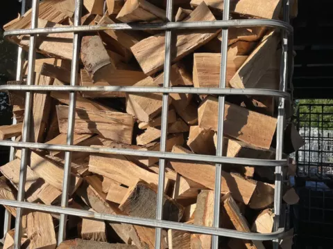 Gitterkorb, bis oben gefüllt mit gespaltenem Buchenholz